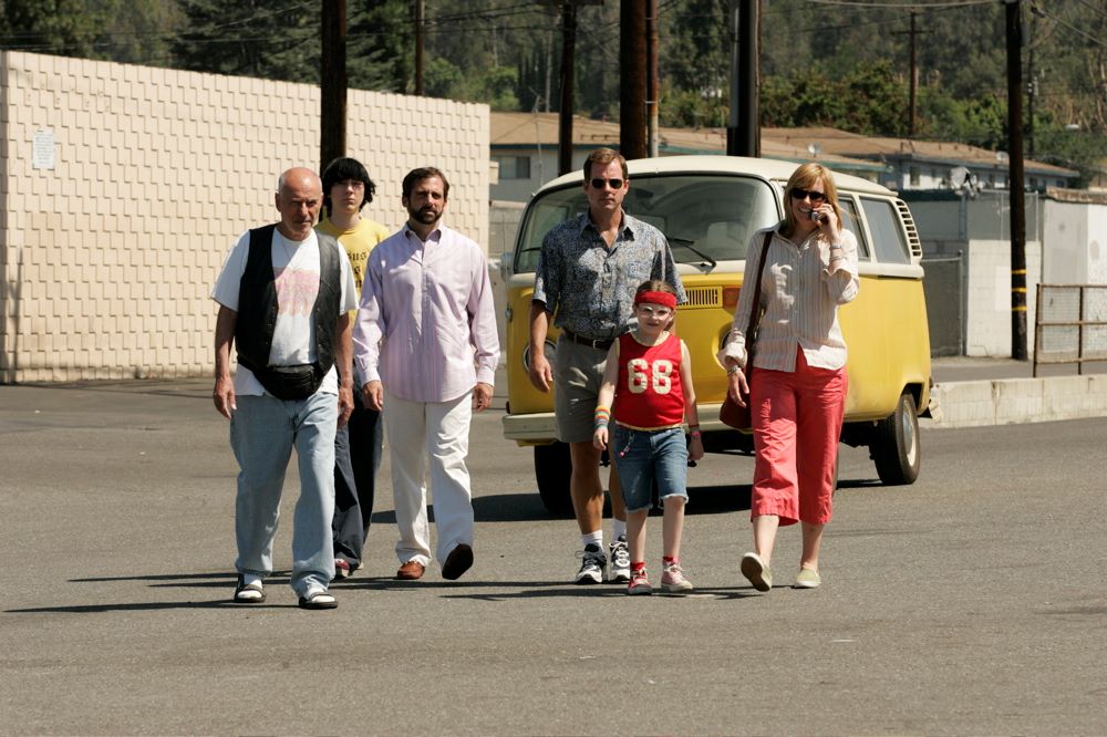 A group of four adults, a teenager, and a child walk away from a VW van.