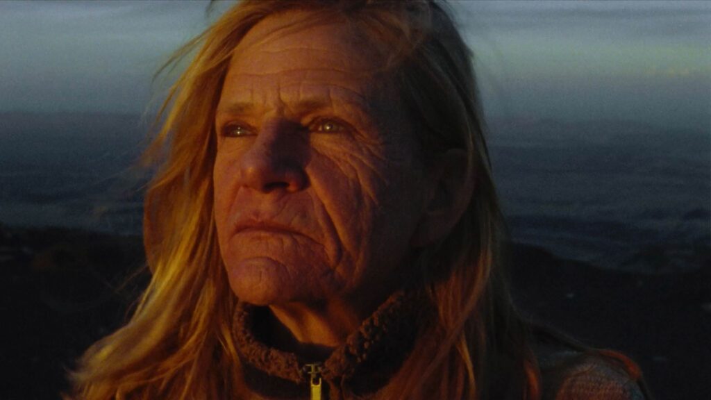 Closeup of older woman with long, blondish hair and lined face