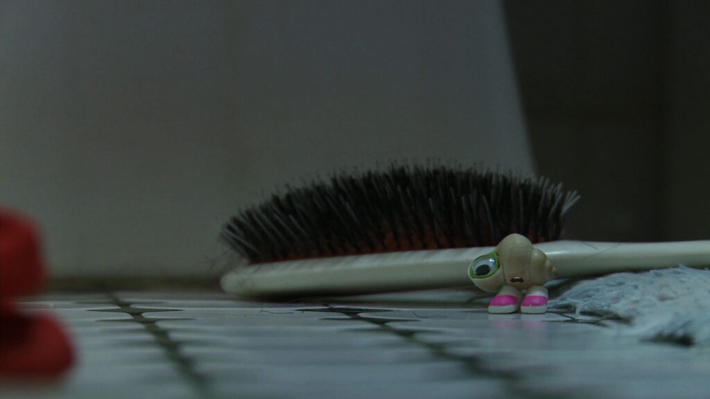 Stop-motion character next to a hair brush.