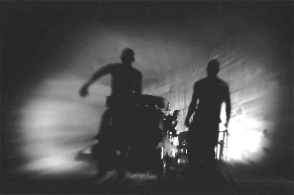 Blurred photo suggesting urgency, of two figures rushing with medical equipment