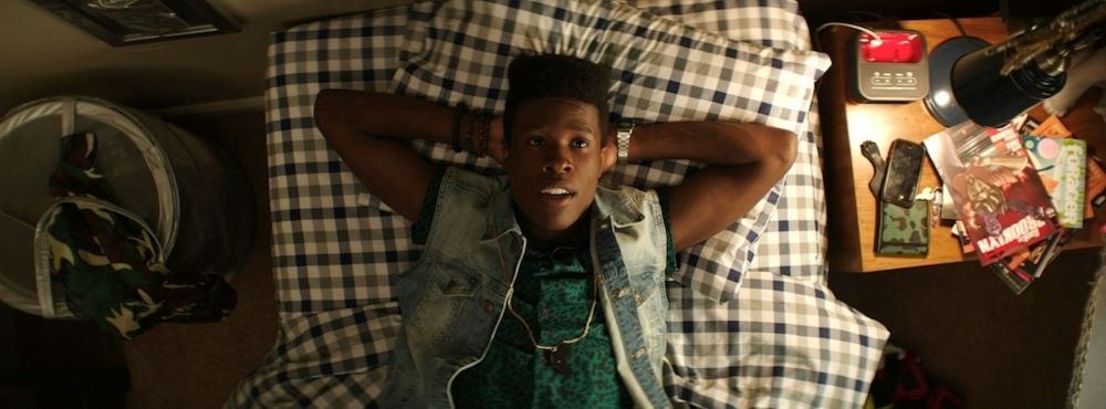 Young Black man lying on a bed