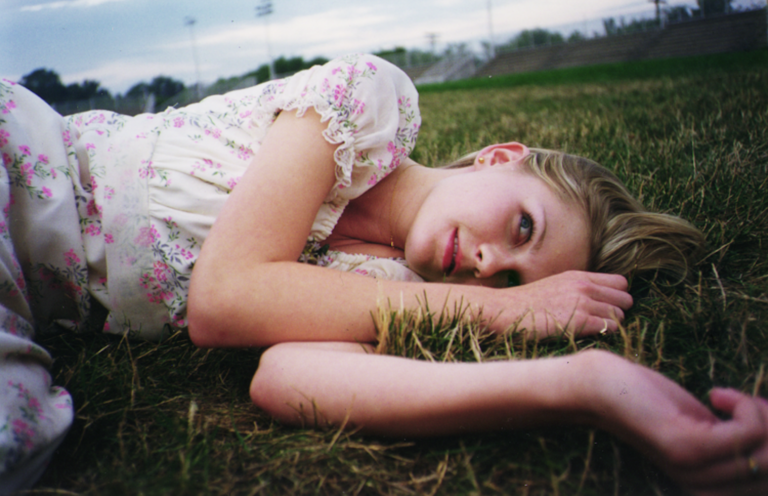 Kirsten Dunst lying in the grass