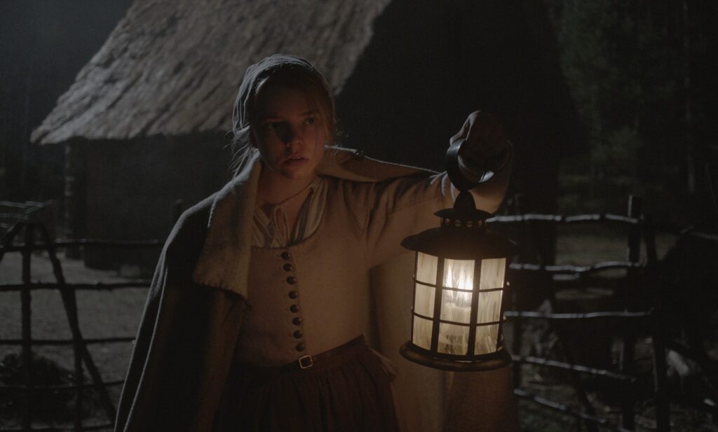 A young woman looks concered as shes carrying a lantern at night