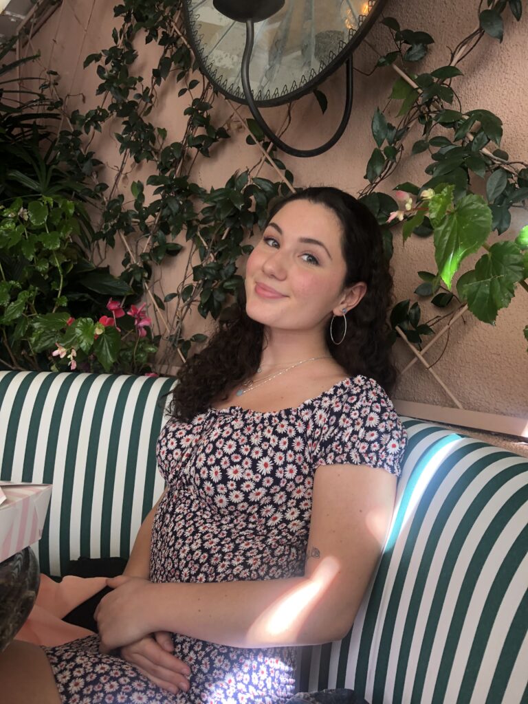 Woman sitting on a couch looking and smiling at the camera