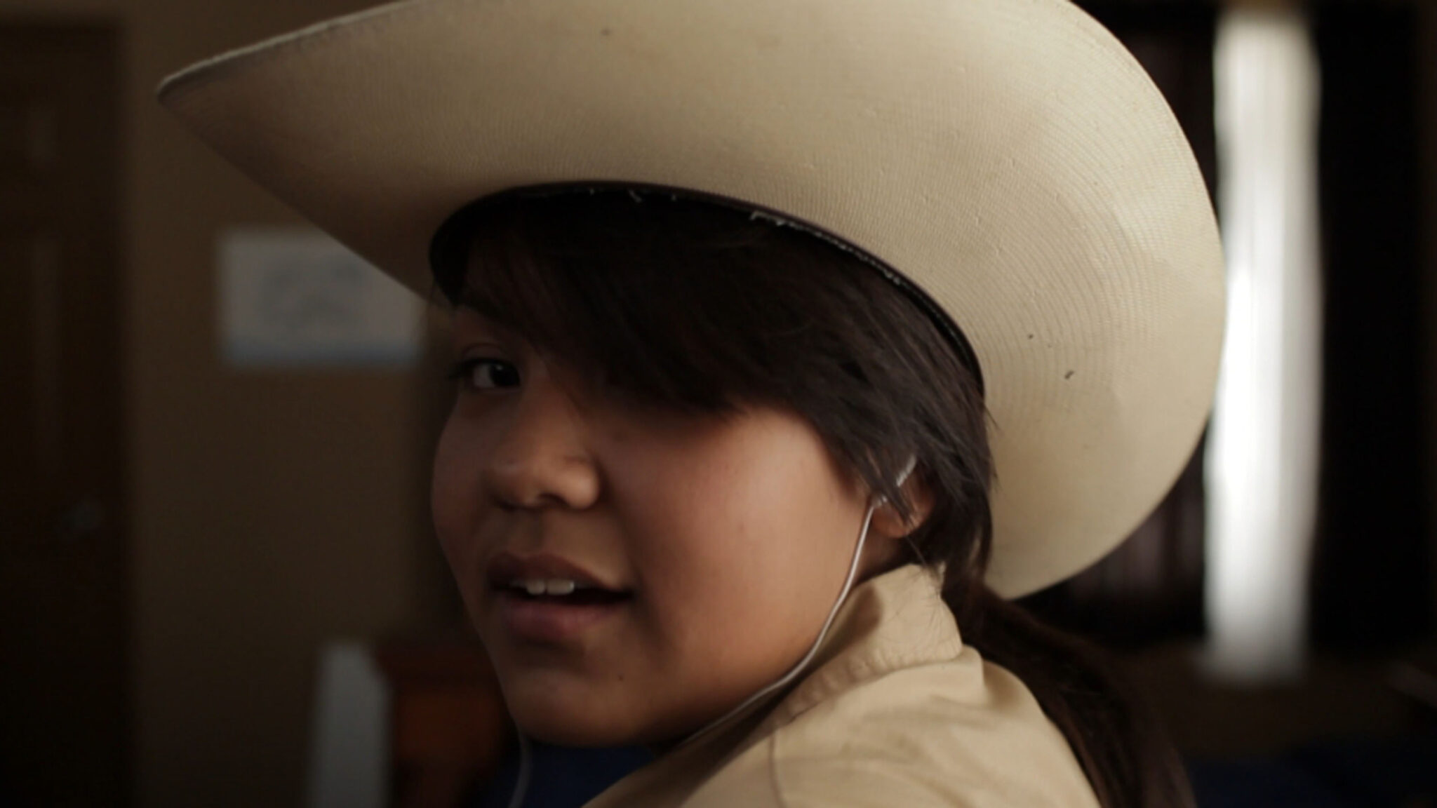 Woman looking at the camera in a cowboy hat