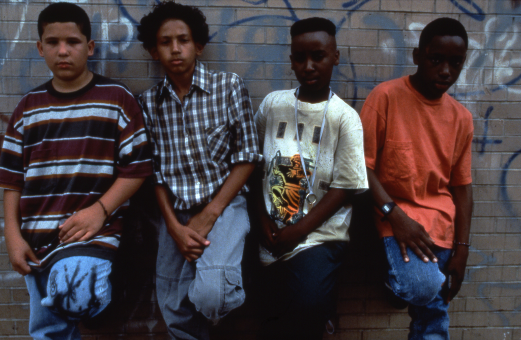 Four teen boys leaning against a wall