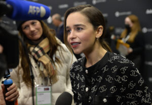 white woman with hair pulled back looking to the left and talking