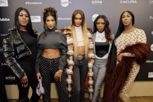 Five women stand in front of a Sundance board.