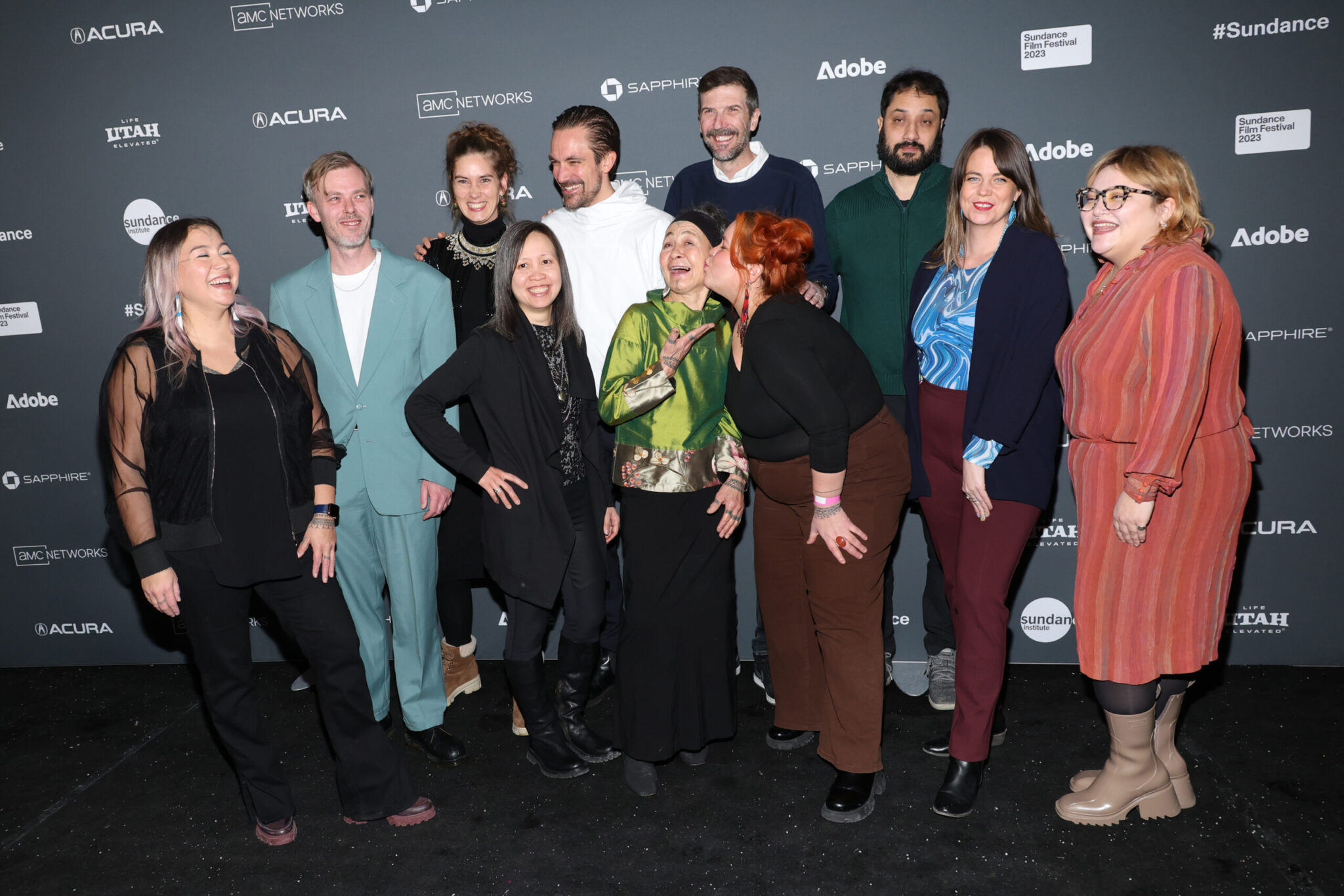 The cast and crew of "Twice Colonized" stand in front of a step and repeat at the 2023 Sundance Film Festival