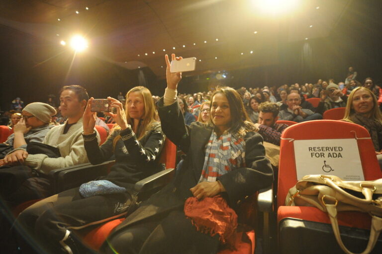 large group of people sitting in theater audience