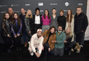 the cast and crew of Sometimes I Think About Dying stands together in front of a step and repeat at the 2023 Sundance Film Festival