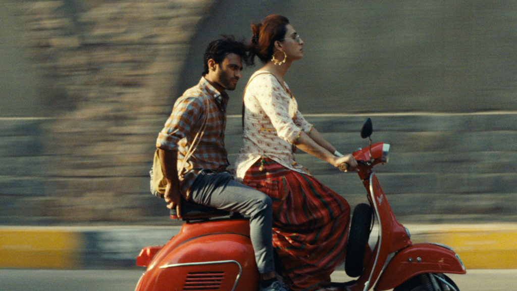 a man and woman on a vespa scooter driving to the right