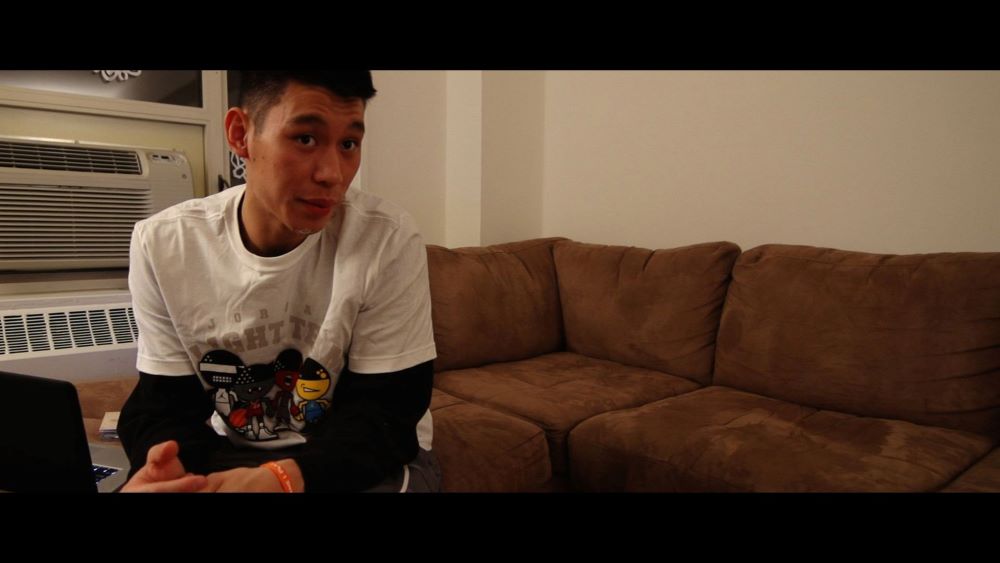 Young Asian man dressed in casual wear sitting in a living room