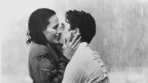 Man and woman embracing and kissing in a pouring rain