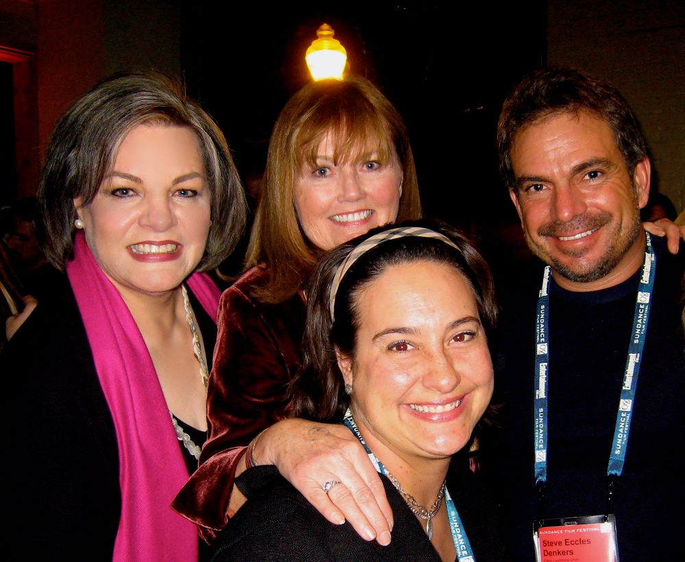 Group photo of three women and a man, all smiling at the camera