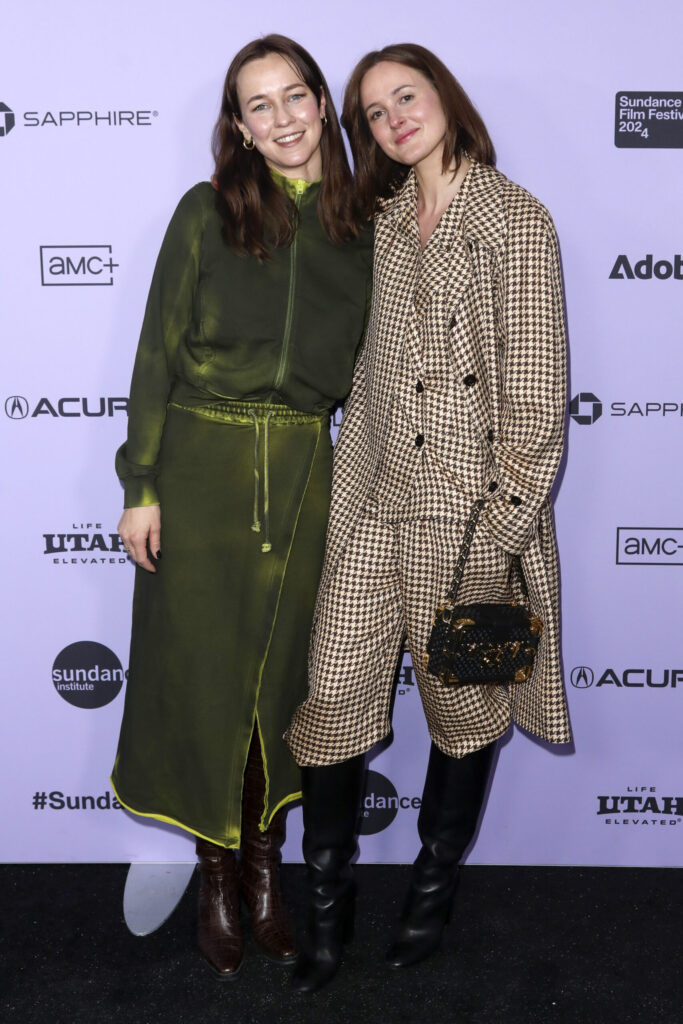 Two women stand in front of a backdrop for the Sundance Film Festival