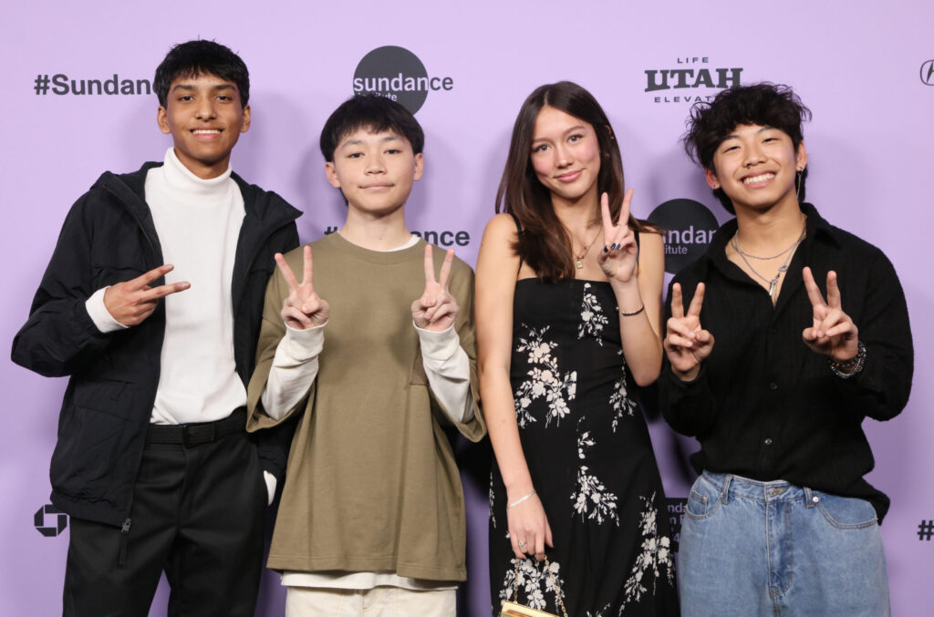 Raul Dial, Izaac Wang, Mahaela Park, and Aaron Chang pose with peace signs in front of a 2024 Sundance Film Festival backdrop.
