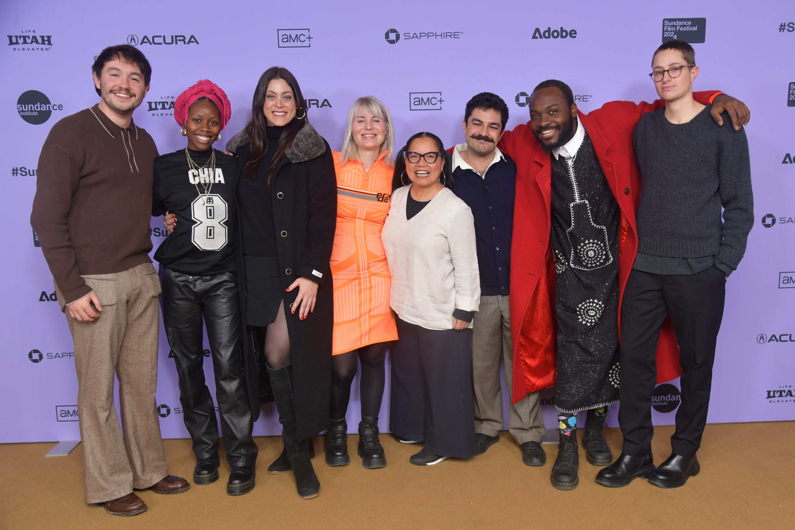 Diverse group of men and women stand in front of a 2024 Sundance Film Festival backdrop