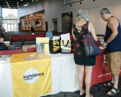 Guests check out an informational booth before a free community screening of 'Won't You Be My Neighbor' in St. George, Utah. Photographer: Christie Berube