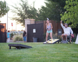 Guests play the backyard classic cornhole before a screening of 'Believer' at the Red Butte Garden Amphitheatre. Photographer: Jonathan Hickerson