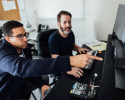 Directing fellow Kobi Libii and editor Paul Frank work on 'The American Society of Magical Negroes' in the editing bay. Photographer: Jen Fairchild