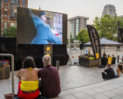 Passersby stop to watch 'Liberations: BIPOC Shorts' during Downtown SLC Open Streets. Photographer: Miguel Mendoza