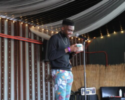 Josh Nkoy performs poetry at a community event held at Sugar Space Arts Warehouse. Photographer: Erika Cespedes