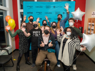 Staff members pose in front of a step and repeat at Satellite Screen Amherst Cinema in Amherst, MA. Photographer: Amherst Cinema