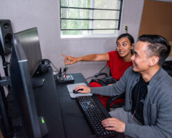 Fellow Dina Amer (left) and editor Lam Nguyen (right) review footage in the editing room during the 2022 Directors Lab. Photographer: Jonathan Hickerson Dina Amer sits beside Lam Nguyen and points at the editing screens