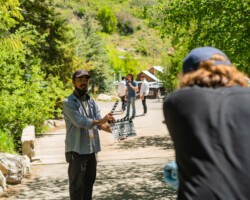 Lab fellow Neo Sora slates a scene for 'Earthquake.' Photographer: Sam Emenogu Neo stands with a slate in an outdoor space