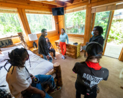 On set with Michael León for 'Crabs in a Barrel.' Photographer: Sam Emenogu Crew members stand in a lodge bedroom