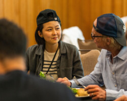 Lab fellow Yuan Yuan (left) and creative advisor Ed Harris (right) during lunch at the 2022 Directors Lab. Photographer: Sam Emenogu Yuan Yuan sits next to Ed, both wearing backwards-facing baseball caps