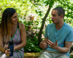 Lab fellow Dina Amer (left) talks with actor Laith Zuaiter (right) on the set of 'Cain and Abel.' Photographer: Sam Emenogu Dina holds a water bottle and sits next to Laith outdoors