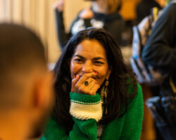 Actor Sarita Choudhury during the 2022 Directors Lab. Photographer: Sam Emenogu Sarita sits, smiling, with her hand near her face, wearing a green sweater