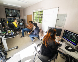 2022 Documentary Edit and Story Lab creative advisor, fellows and editors working in the editing room. Photographer: Miguel Mendoza Individuals are dispersed throughout the editing trailer, working on footage
