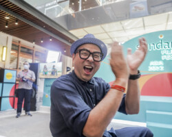Michael Y. Chow gives enthusiastic applause during Opening Night. Photographer: Herka Yanis Pangaribowo Michael sits with an elated facial expression and blurred hands as he claps