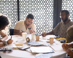 2025 Building Bridges fellows Aya Hamdan, Omar Al Dakheel, Yusuf Ahmed, and Tarek Albaba take note during a meeting. Photographer: Elyse Butler