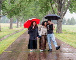 2026 Documentary Film Producers Lab fellows Chelsea Hernandez (‘The School of Hope’), Cherrelle Swain (‘Southmont Drive’) and Hansen Lin (‘God Lives Here’) brave the rain together. Photographer: Jenae Neeson